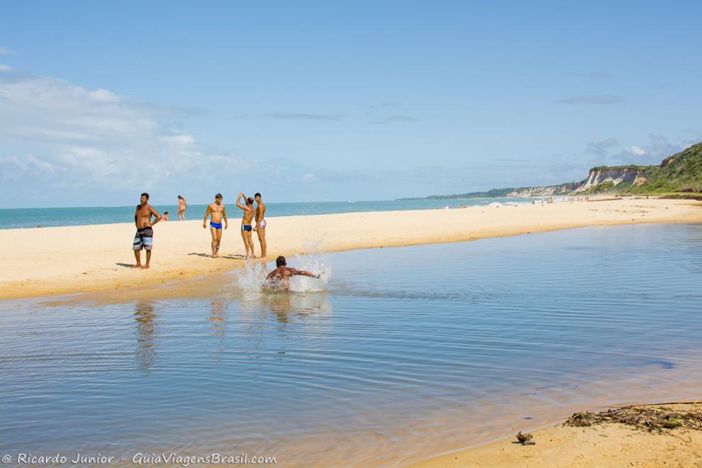 Imagem da piscina natural, de um banco de areia e ao fundo o mar da Praia de Pitinga.
